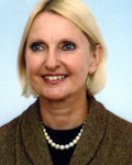 Prof. Maria Siemionow A woman with blonde hair, dressed in a stylish jacket and adorned with a necklace, exudes confidence and elegance.