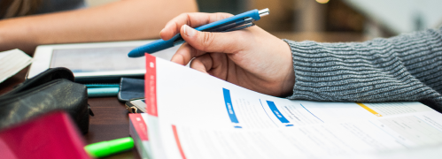 A person writes on a piece of paper with a pen, capturing thoughts and ideas in a focused manner.